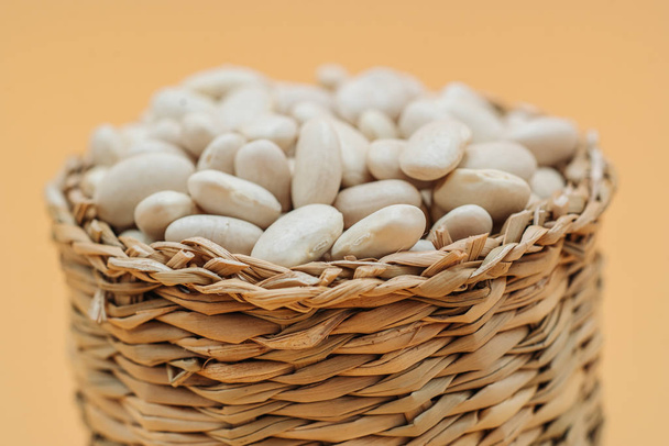 Healthy organic dried white beans in a straw basket - Photo, Image