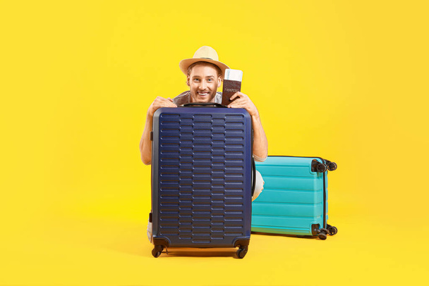junger Tourist mit Gepäck auf farbigem Hintergrund - Foto, Bild