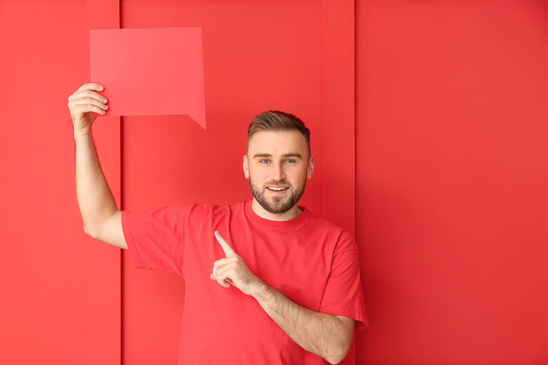 Young man with blank speech bubble on color background - Фото, изображение