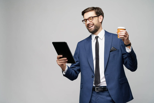 Young Businessman holding digital tablet pc pad and paper cup of coffee - Fotografie, Obrázek