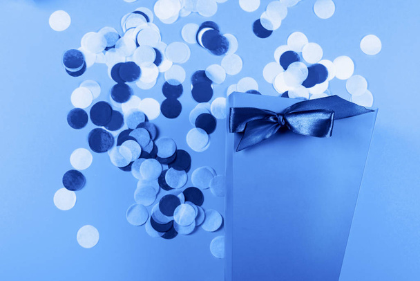 Blue box with scattered confetti. - 写真・画像