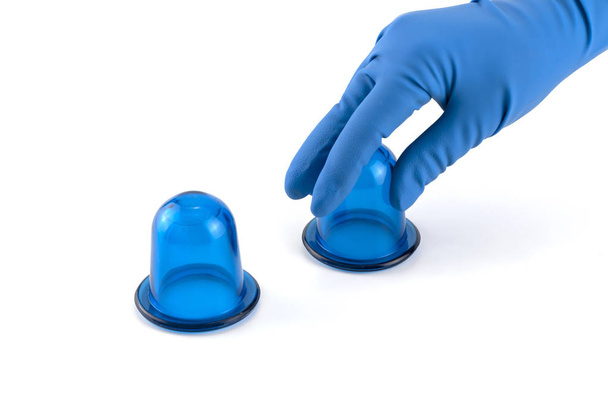 hand in medical glove holding blue anti-cellulite vacuum silicone body jars - Foto, afbeelding