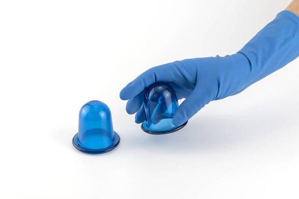 hand in medical glove holding blue anti-cellulite vacuum silicone body jars - Photo, Image