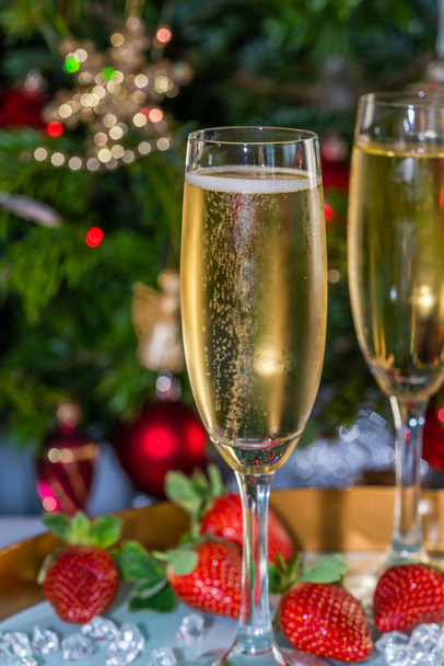 Champagne in glasses with strawberries on festive background - Foto, afbeelding