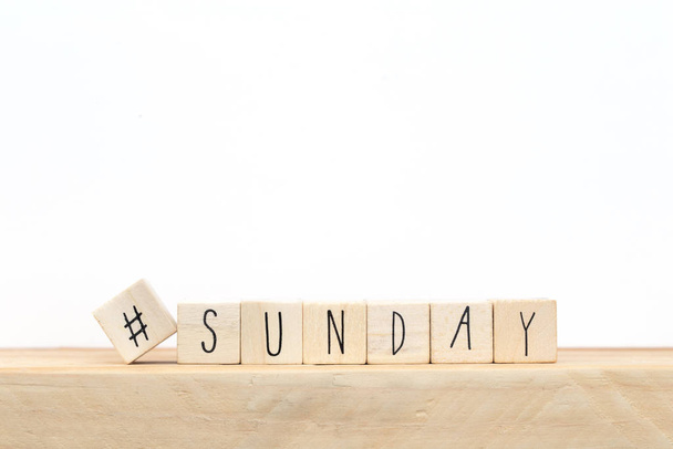 Wooden cubes with a hashtag and the word Sunday, social media concept near white background - Foto, imagen