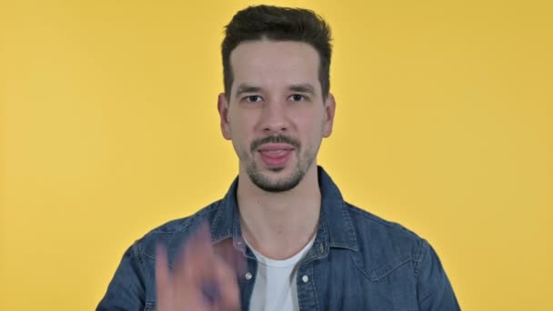 Portrait of Cheerful Young Man doing OK Sign, Yellow Background - Filmati, video