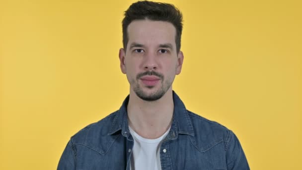 Portrait of Ambitious Young Man doing Thumbs Up, Yellow Background - Materiał filmowy, wideo