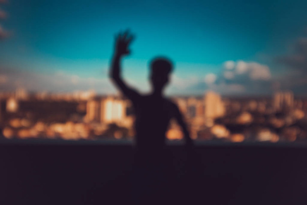 Silhouette d'un jeune homme sur fond d'horizon de la ville
 - Photo, image