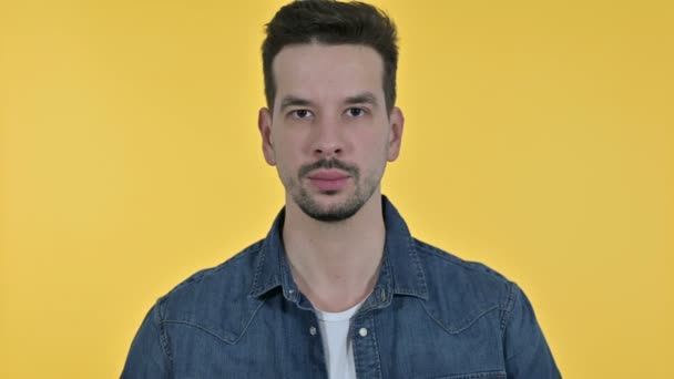 Portré vonzó fiatalember mond nemet Ujj, sárga háttér - Felvétel, videó