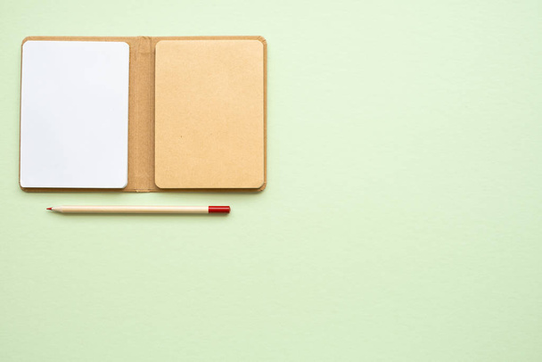 Open Blank new eco notepad and pensil on light green background, copy space, top view  - Photo, Image