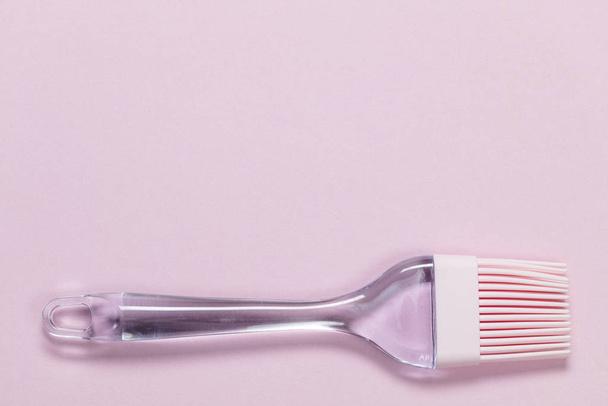 Pink silicone brush on light pink background, close up, copy space top view , top view, above - 写真・画像