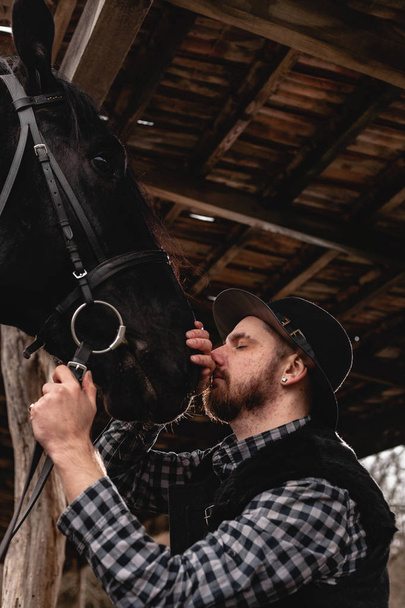 Portrét chlapa v klobouku s černým koněm. - Fotografie, Obrázek