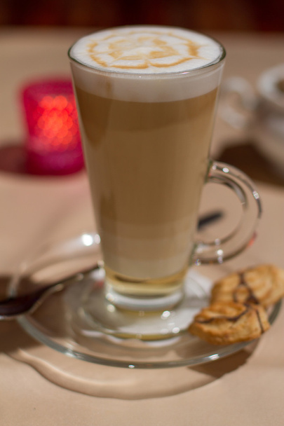 Image of hot cappuccino in glass on table with cookies - Foto, Imagen