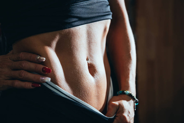 detail of the body fitness of a girl, with a piercing in navel and nails painted - Photo, image