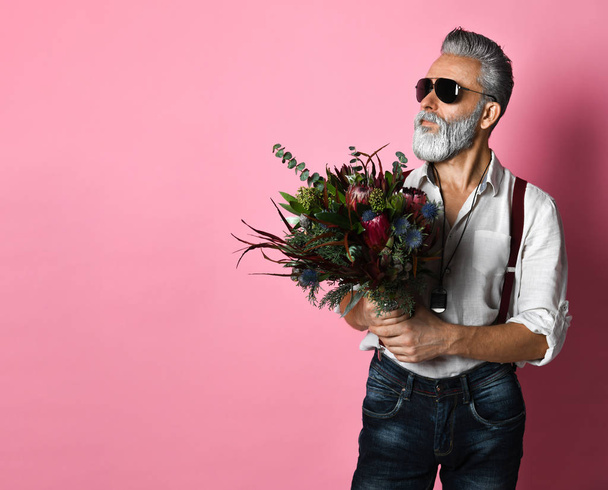 Stylish bearded middle-aged man with flowers. looking away - Φωτογραφία, εικόνα