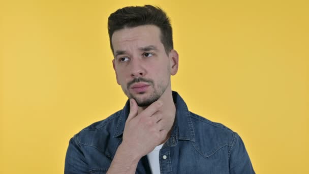 Portrait of Attractive Young Man Thinking and getting Idea, Yellow Background - Felvétel, videó