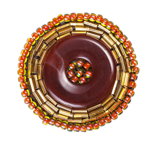 Broche en cuir décorée de perles et de clairons en verre
 - Photo, image