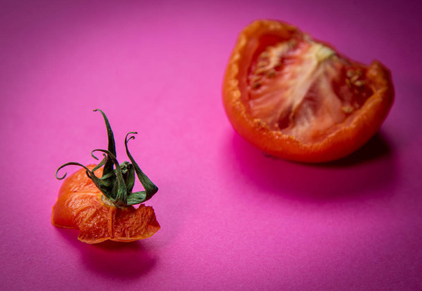 Fatia de tomate vermelho podre vegetal isolado em uma magenta de volta
 - Foto, Imagem