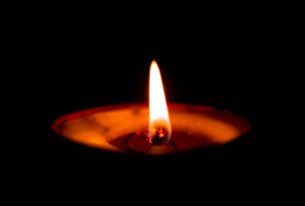 Butterlamp / Wax Candles / Diwali batti / Diya Burning in the dark. Een boterlamp gloeit in het donker. selectieve focus - Foto, afbeelding
