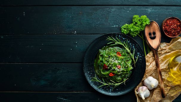Seaweed salad on a black stone plate. Chinese cuisine. Top view. Free copy space. - 写真・画像