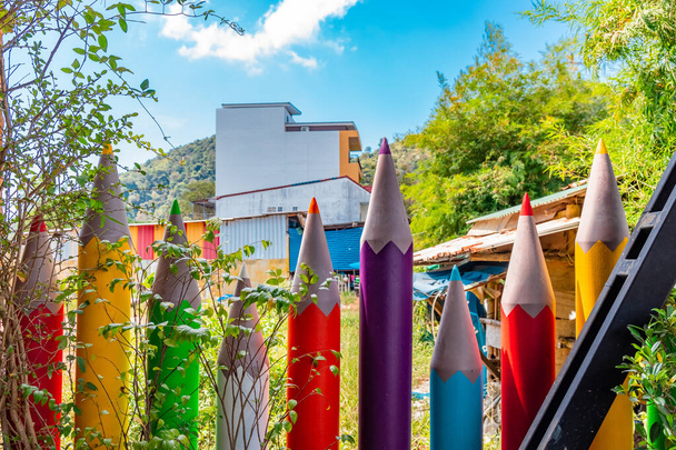 lápis de cera coloridos colocados como uma cerca em torno de um jardim
 - Foto, Imagem