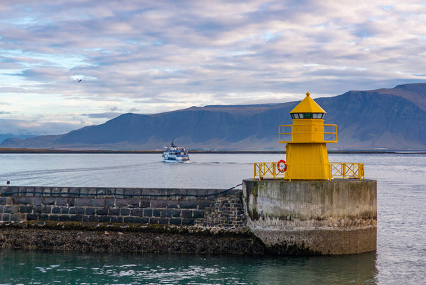Small yellow lighthouse at the entrance of the port of Reykjavik - Fotoğraf, Görsel