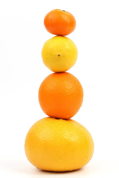 柑橘系の果物は白い背景の上互いに垂直に立つ - 写真・画像