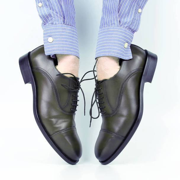 Classic brown shoes worn on the hands on a white background - 写真・画像