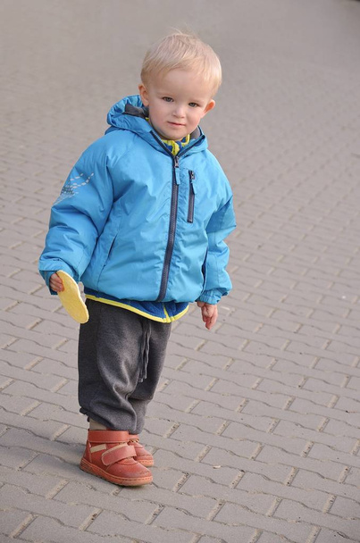 Sokaklarda tek başına dolaşan küçük sarışın bir çocuğun portresi..  - Fotoğraf, Görsel