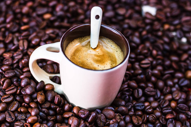 Close up de xícara de café, grãos de café torrados no backgroun vermelho
 - Foto, Imagem