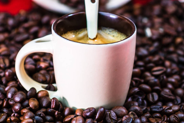 Крупним планом чашку кави, смажені кавові зерна на червоному фоні
 - Фото, зображення