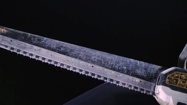 Close-up of powerful electric saw blade on black background. Stock footage. Large reciprocating electric saw for professional carpentry - Footage, Video