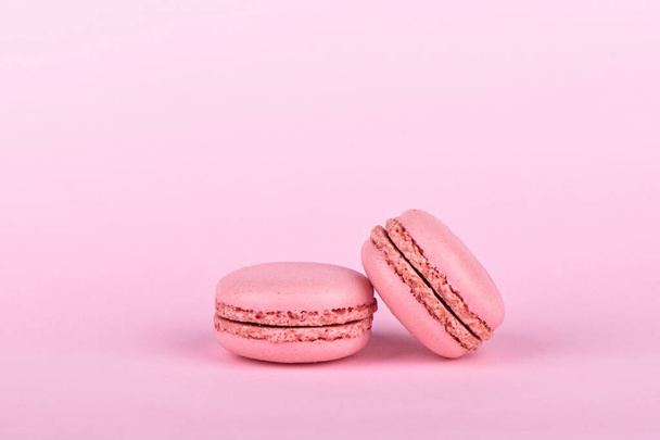 Two pink macaroons isolated on a pink background. - Φωτογραφία, εικόνα