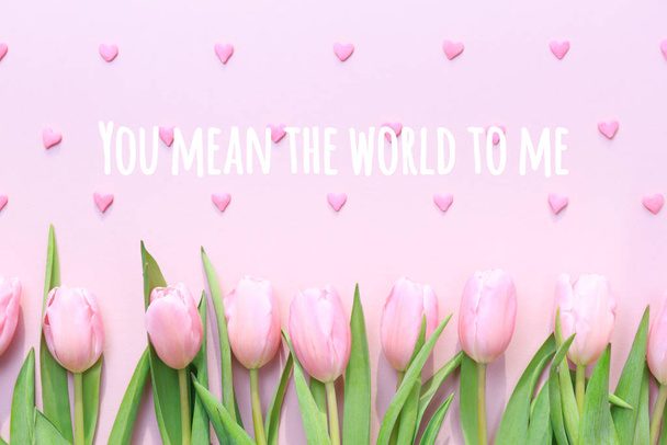Jesteś dla mnie całym światem z różowymi tulipanami i różowym serduszkiem na różowym tle. Płaskie łóżko, widok z góry. Walentynki - Zdjęcie, obraz