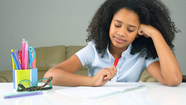 schoolgirl is thinking about school homework doing homework - Photo, Image
