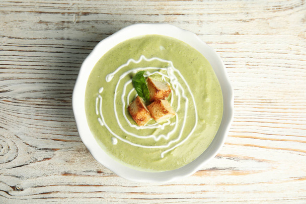 Delicious broccoli cream soup with croutons served on white wooden table, top view - Foto, Imagem