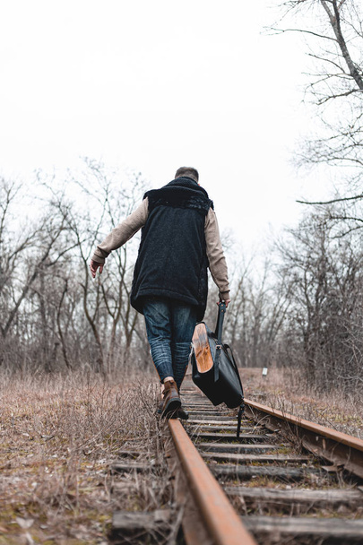 A man on the railway steps on a journey from hustle and bustle. Stock photo. - Photo, image
