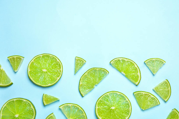 Juicy fresh lime slices on light blue background, flat lay. Space for text - Valokuva, kuva