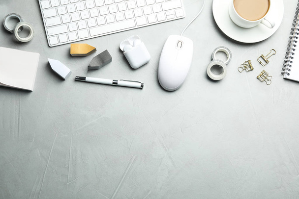 Flat lay composition with wired computer mouse and stationery on light grey table. Space for text - Foto, Bild