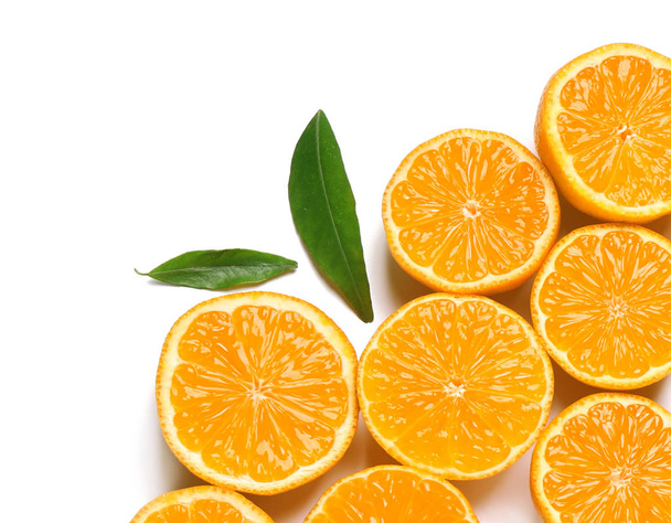 Composición con mitades de mandarinas frescas maduras y hojas sobre fondo blanco, vista superior. Cítricos
 - Foto, Imagen