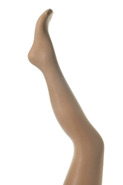 Maniquí de pierna en mallas beige sobre fondo blanco
 - Foto, Imagen