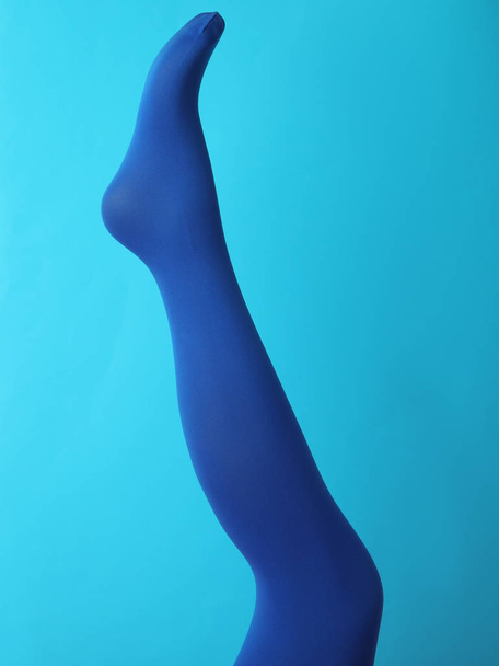 Leg mannequin in blue tights on color background - Foto, imagen