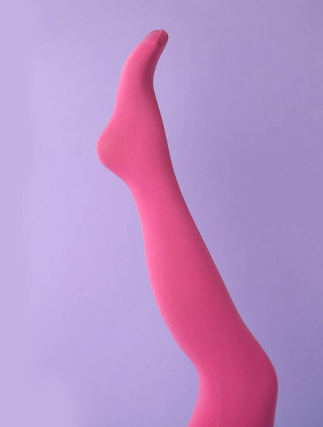Leg mannequin in pink tights on violet background - Foto, afbeelding