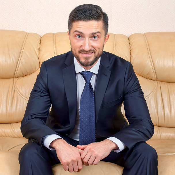 homem de negócios bem sucedido sentado em um sofá de couro
 - Foto, Imagem