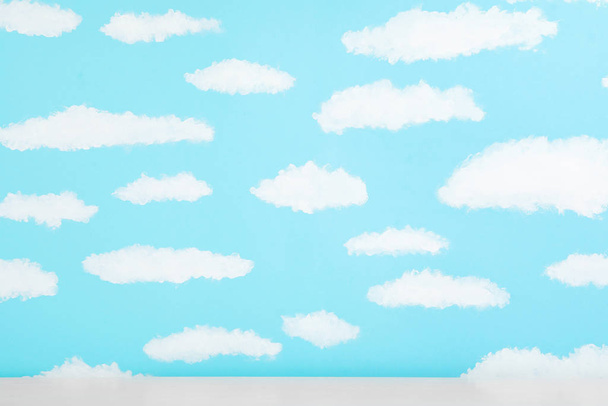 White table near wall with painted blue sky. Idea for baby room  - Valokuva, kuva