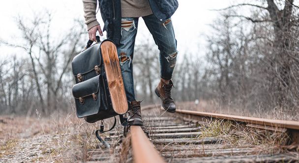 Un tipo con botas de gamuza de otoño en el ferrocarril. El concepto de senderismo, viajes ropa práctica, zapatos
. - Foto, imagen