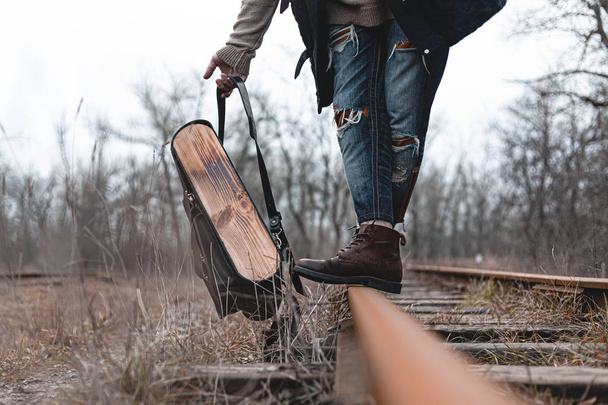 Een man in suède herfstlaarzen op de spoorlijn. Het concept van wandelen, reizen praktische kleding, schoenen. - Foto, afbeelding