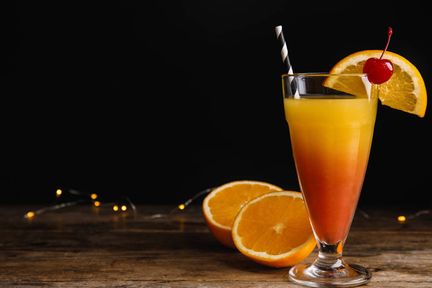 Fresh alcoholic Tequila Sunrise cocktail on wooden table. Space or text - Fotó, kép