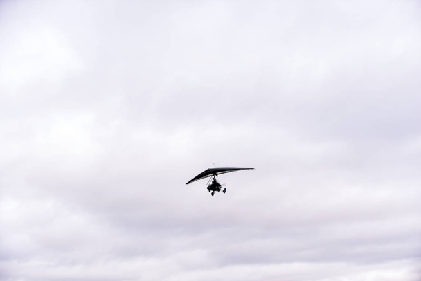 A látóhatár felé repülő személy kisméretű légi járművön - Fotó, kép
