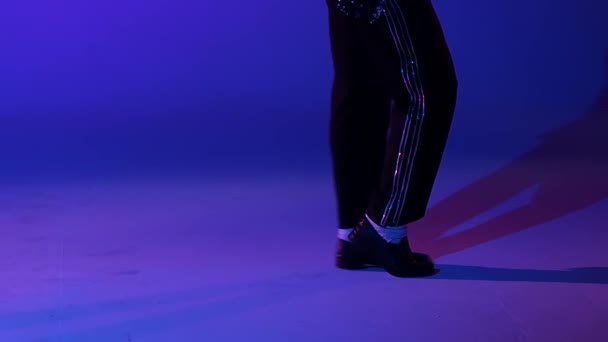 Young stylish man dancing in style Michael Jackson, spotlight on a blue background. Close up of legs, slow motion. - 映像、動画